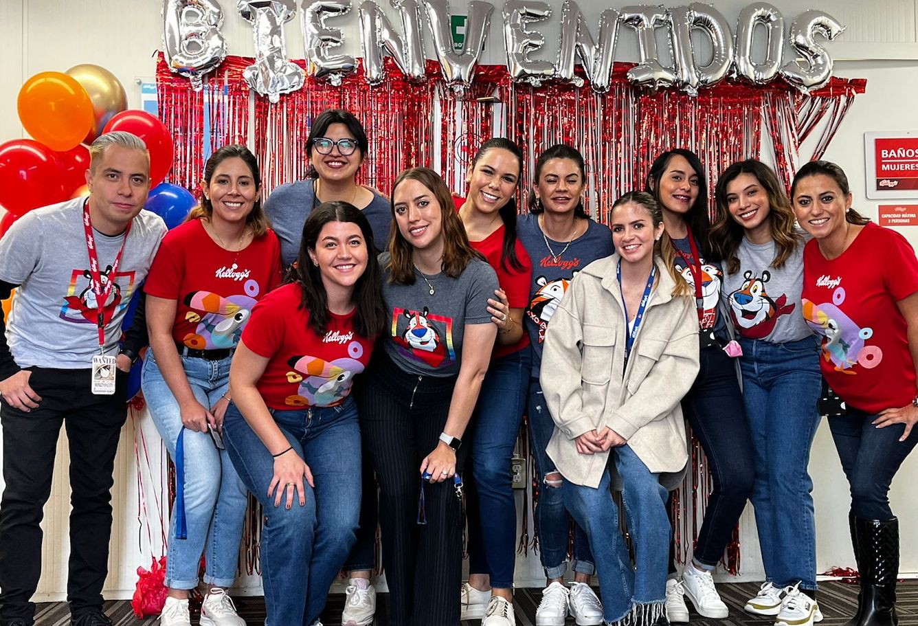 Kellanova employees standing in front of balloon banner that reads Bienvenidos